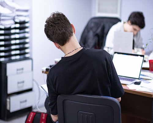 Person working at a desk with laptop focusing on posture